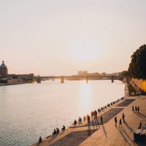 people sitting beside lake